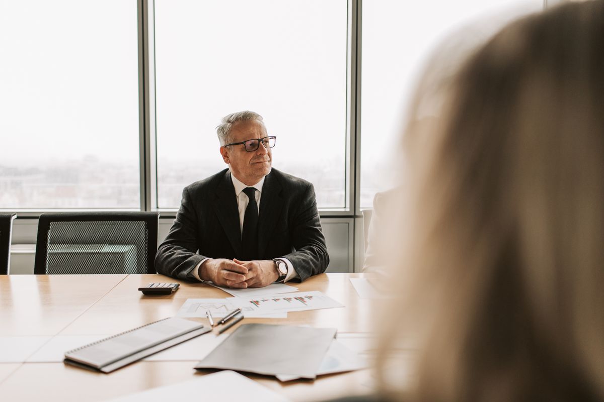 Senior executive in a high-stakes interview setting Senior executive in a high-stakes interview setting